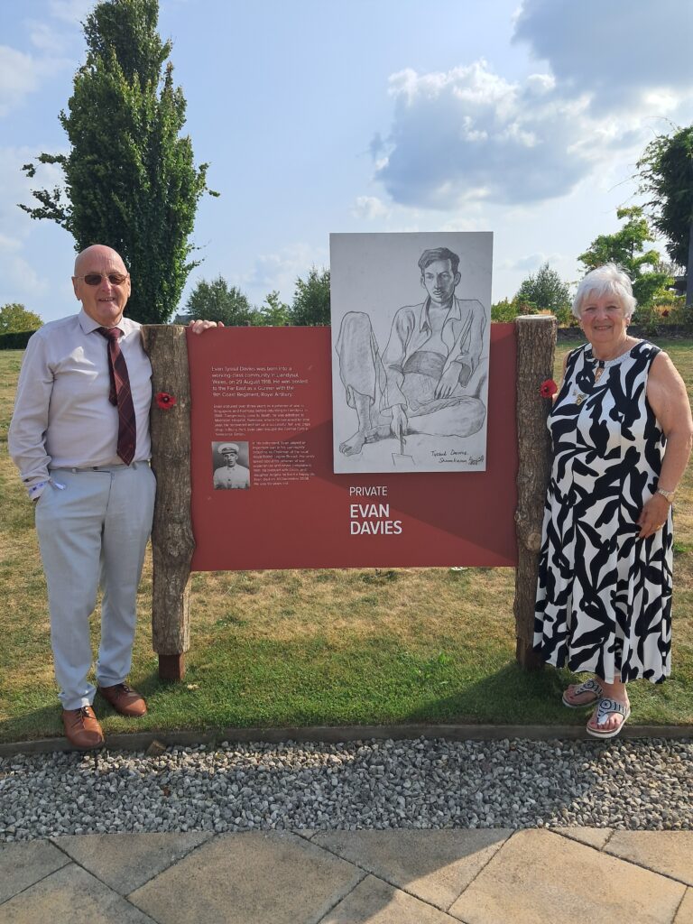 Angela Williams standing beside her father Evan Tyssul Davies' portrait at the VJ80 exhibition, National Memorial Exhibition portrait at the VJ80 exhibition - a story digitising memory to safeguard the future