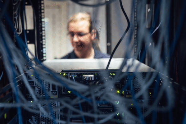 BCC IT engineer working behind secure server rack during infrastructure and cyber security review