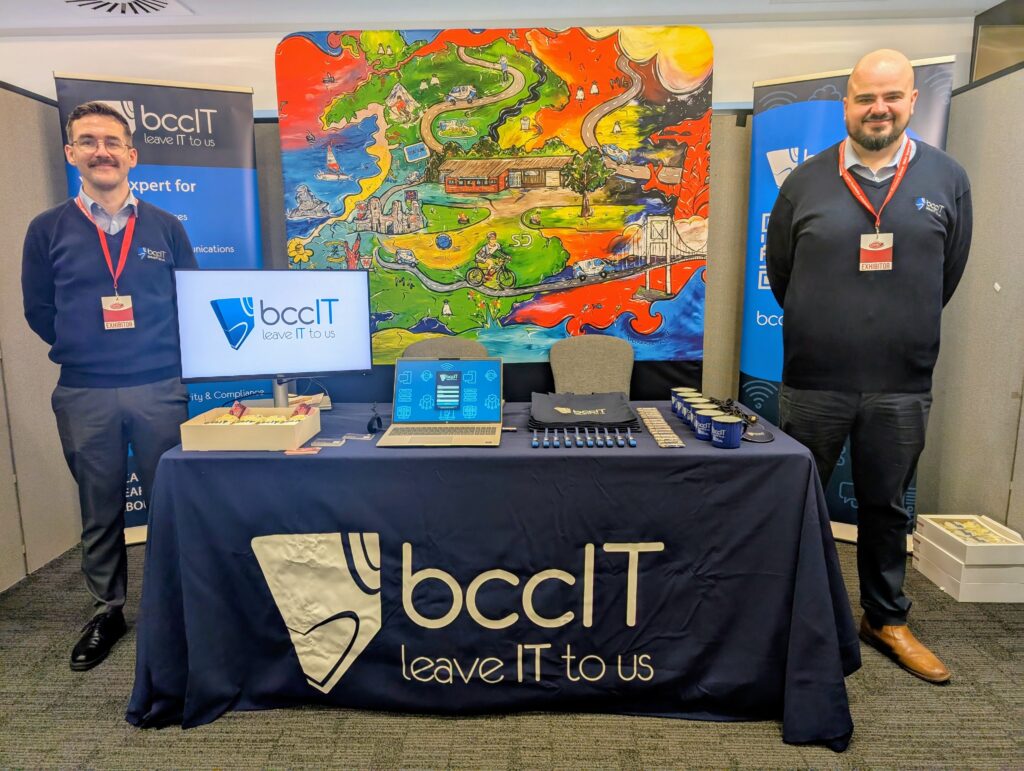 BCC IT Sales team representing the company at the Welsh Business Exhibition at Llanelli.com Stadium, standing at the company's branded stand and speaking with visitors about IT and cybersecurity solutions.