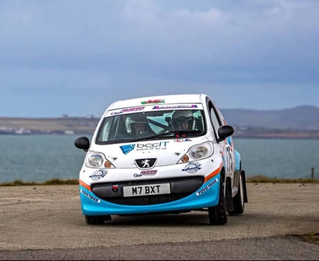 Ioan Thomas rally driver in Peugeot 107 with BCC IT sponsorship branding